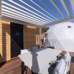 白いパーゴラとメルバウウッドデッキの明るいテラス