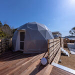 浜名湖を望むグランピング施設のドーム型テントとウッドデッキ