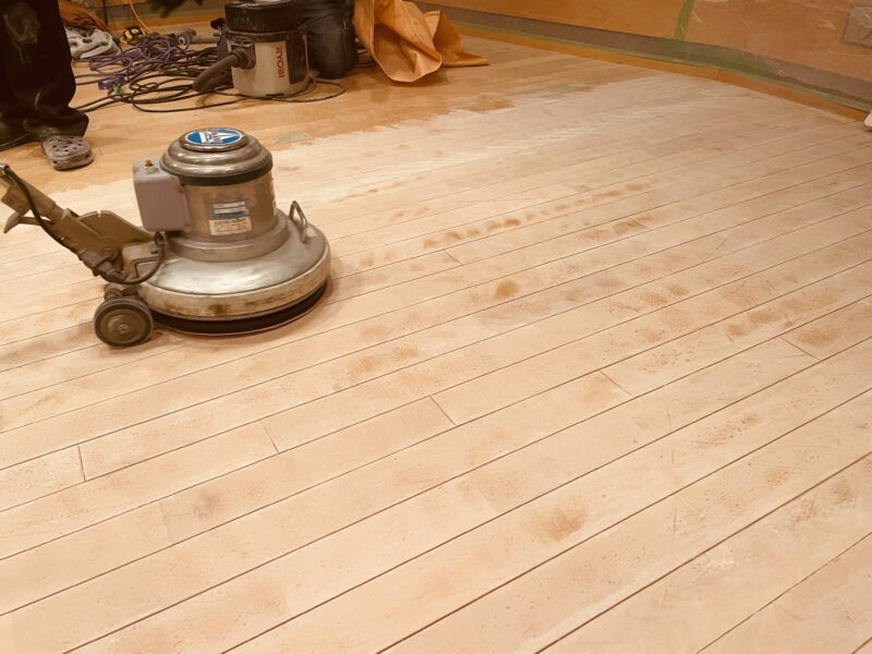 業務用ポリッシャーで無垢フローリングを研磨する職人