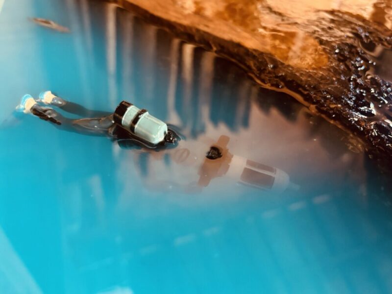 ブルーのレジンの中を泳ぐスキューバダイバーのフィギュア