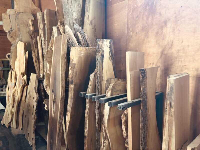 奈良アトリエに保管された無垢材のストック。花梨・オリーブ・パンガパンガ・モンキーポッドなど多彩な銘木が揃い、レジンテーブルや一枚板テーブルに最適。
