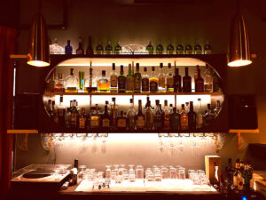 阪急芦屋川のバーTBDBのバックバーに並ぶウイスキーボトルとグラス