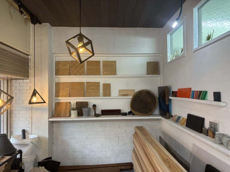 事務所の壁面に並ぶ無垢フローリングとレジンサンプル