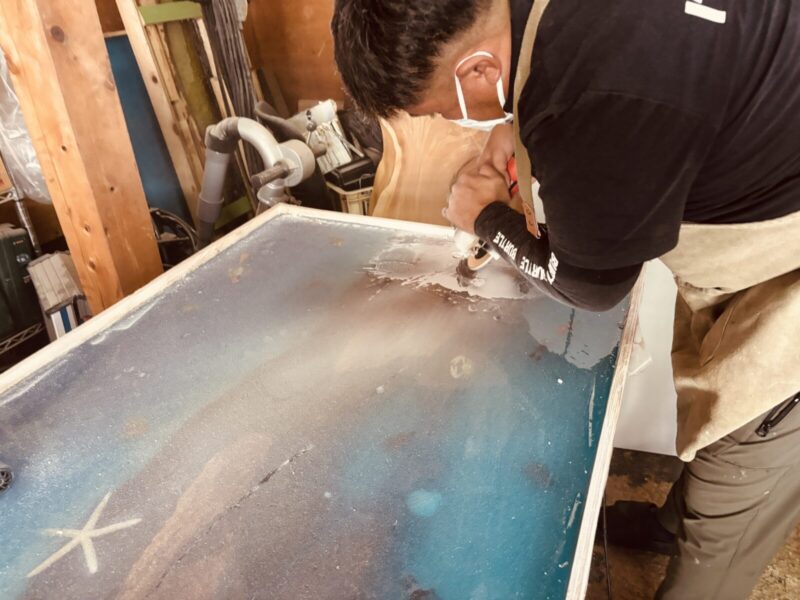 レジンテーブルの気泡補修をグラインダーで行う様子