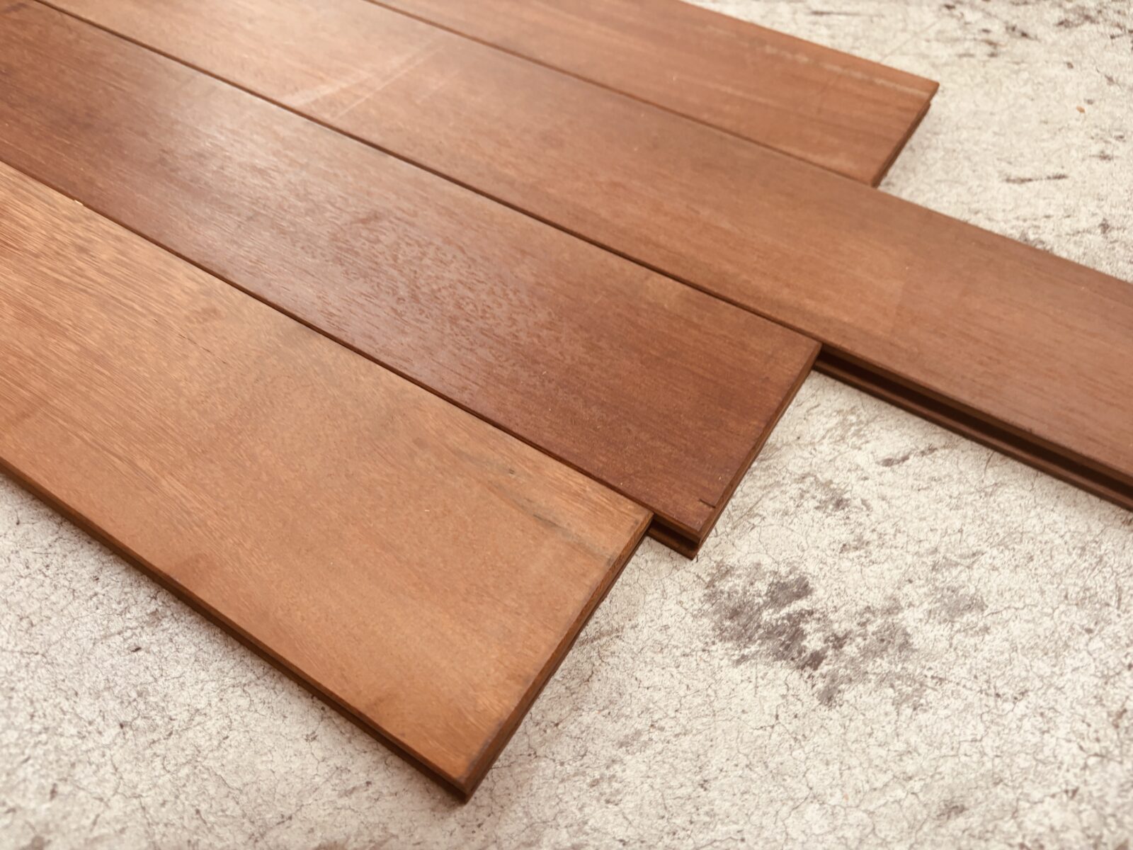 数枚のウリン無垢フローリングを床に並べた写真、自然な木目の表情が見える