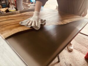 布でレジンテーブルの表面を仕上げる新入社員。#10000番までの研磨を目指して奮闘中。