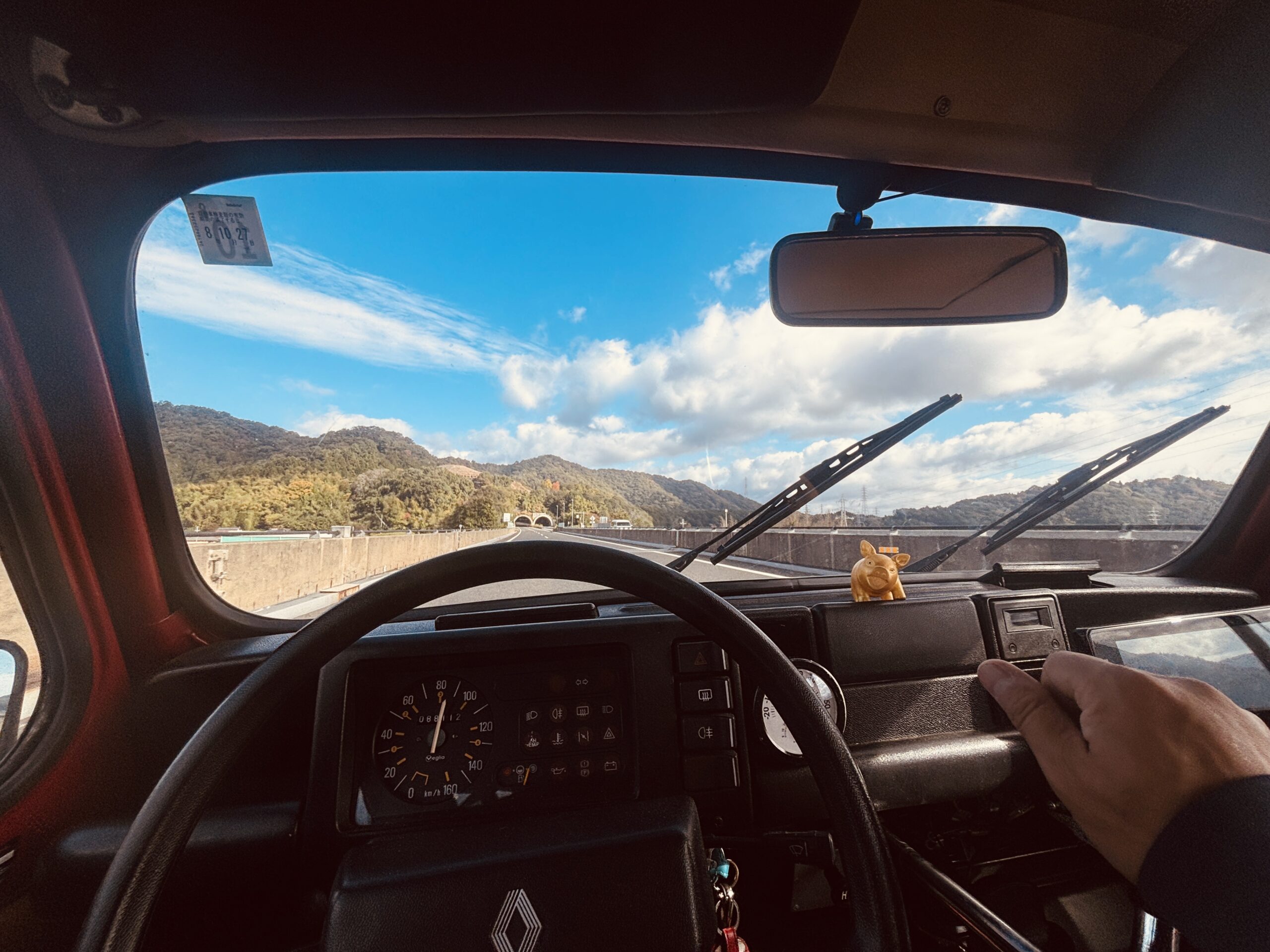 ルノー4の運転席から見える山々と青空。レトロなメーター越しの景色