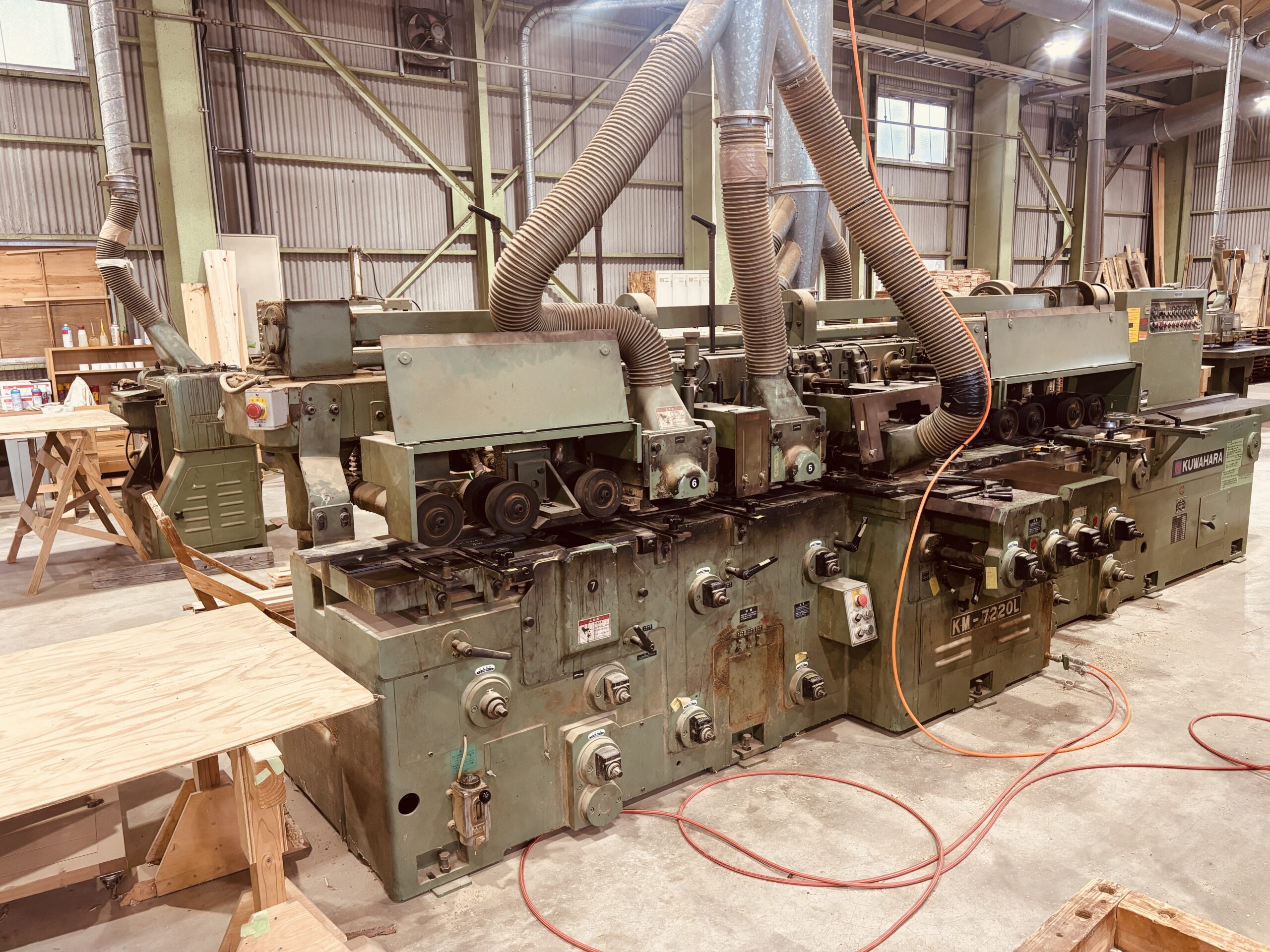 複数の刃で一度に加工できるKUWAHARA製モルダー。無垢フローリングや家具材の成形に使用される木工機械。