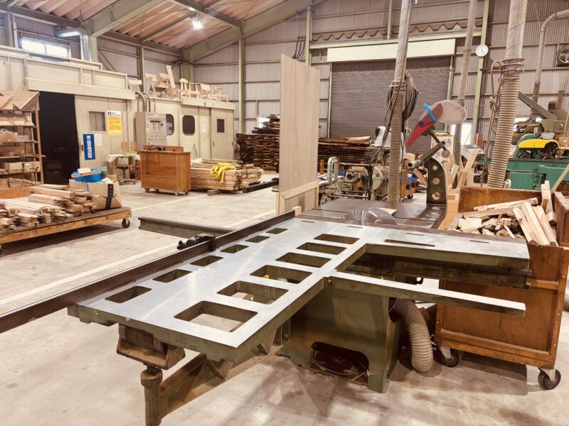 大型のスライドソーで無垢材を正確にカットする作業台。家具製作やレジンテーブルの素材づくりに用いられる。