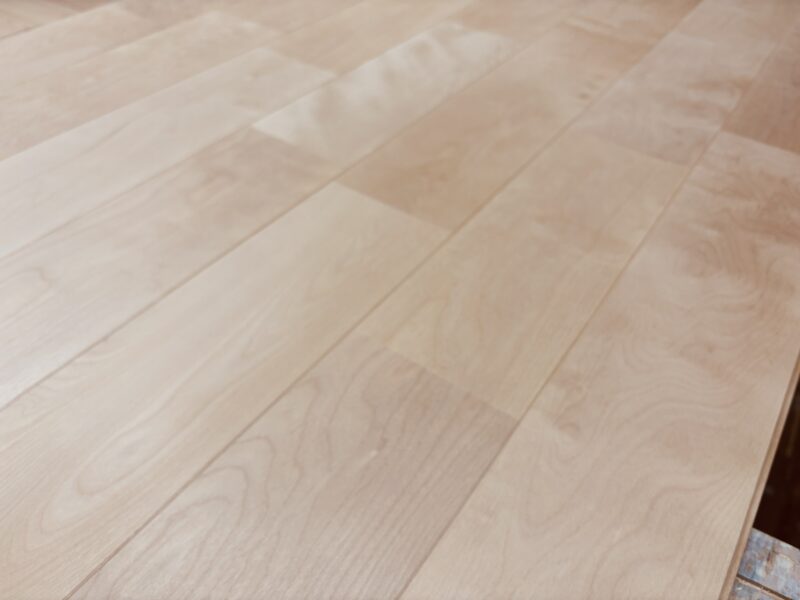 白木仕上げによってやさしい白さが広がるバーチ無垢フローリングの木目。