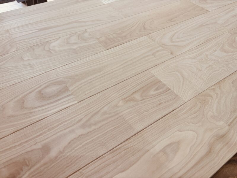栗（クリ）ユニタイプ無垢フローリングを横方向に並べた様子。波状の杢目が特徴的。