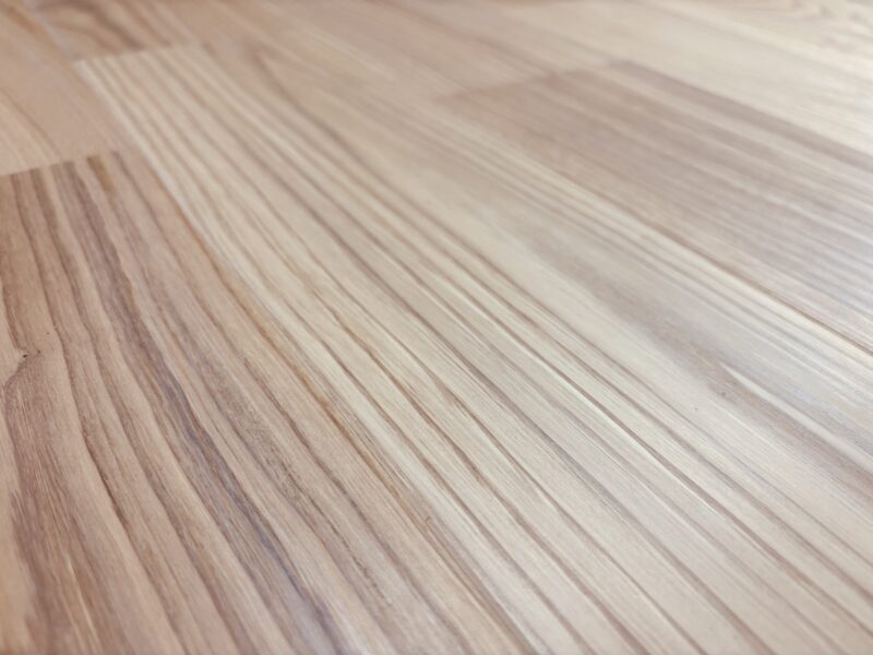 淡い色調のチェスナット無垢フローリングにクノス白木を塗装した明るい仕上がりの写真