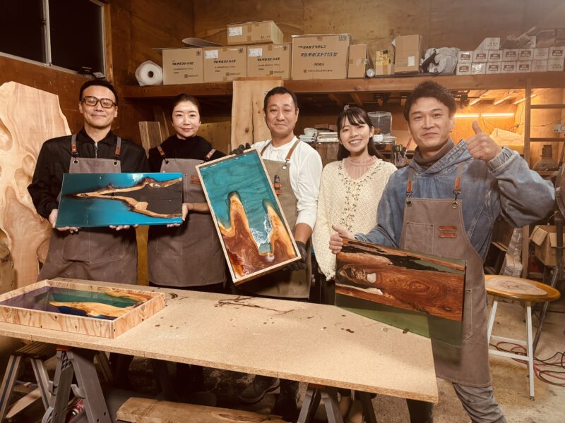 エコロキアのアトリエで、完成したレジン作品を手に笑顔で並ぶ参加者たち。ポプラやオリーブ、波レジンなど多彩な作品が揃った制作体験後の集合写真。