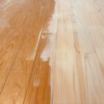 ヒノキ無垢フローリングを研磨して再生している途中の様子。右側は削りたての明るい木肌、左側は経年劣化した古い塗膜が残っている状態。