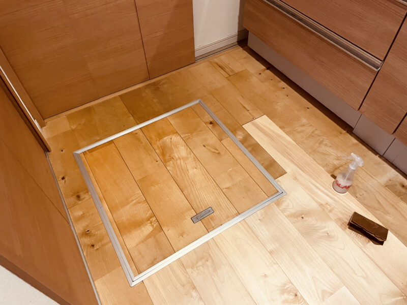 床下点検口まわりの無垢フローリングを研磨前に確認している様子。