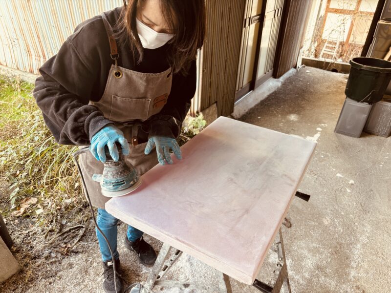 元参加者さんがサンダーを使ってレジン天板の表面を丁寧に研磨している様子。細かい粉が舞い、集中した空気が漂う瞬間。
