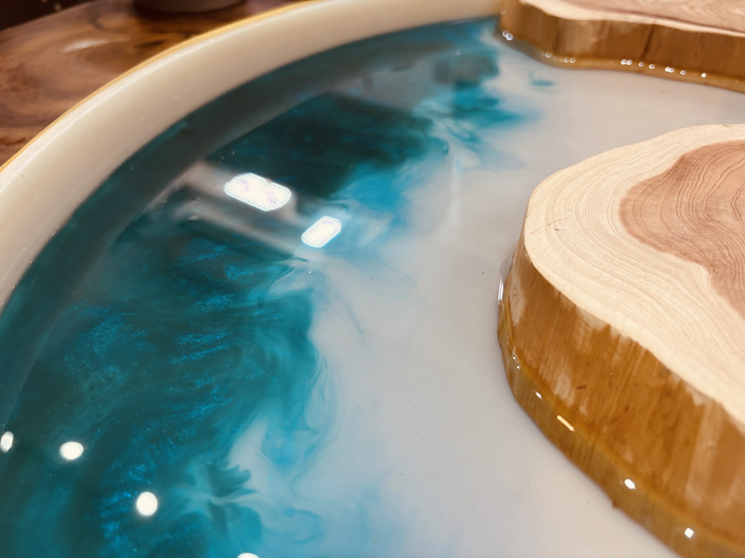 海をイメージしたブルーグリーンのレジンが広がる丸型レジンテーブル制作途中