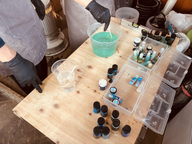 レジンテーブル制作体験ワークショップで、複数の青系顔料を使って色を調整する作業風景