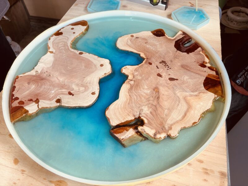 カイヅカイブキを島のように配置し、ブルーグラデーションのレジンを流し込んだ円形レジンテーブル