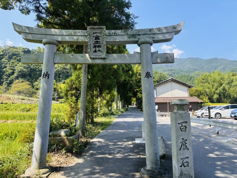 御所市・一言主神社の大きな石造鳥居。背後には緑豊かな山並みと農村風景が広がる参道入口。