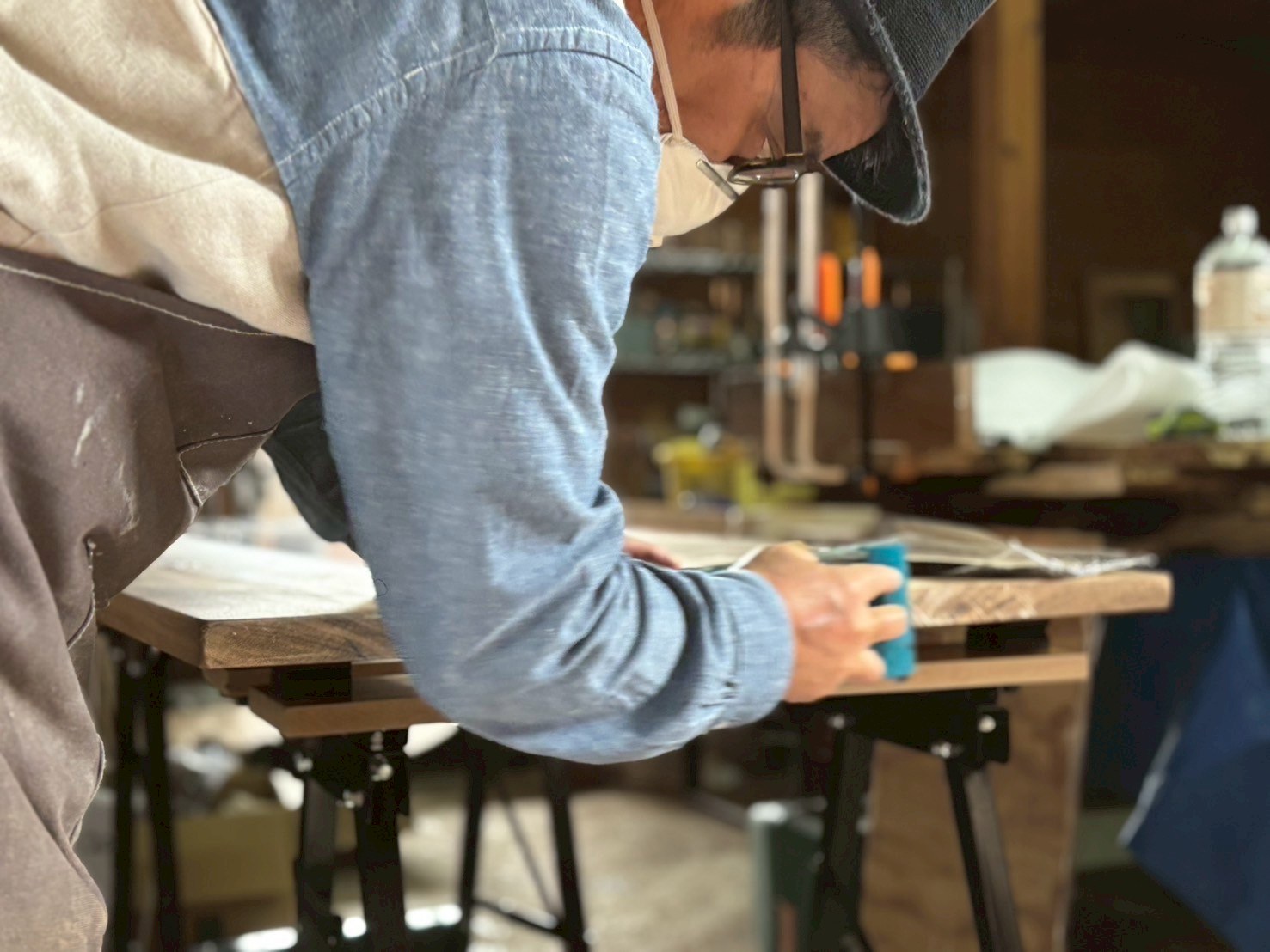 レジンテーブルの端部を丁寧に研磨する参加者さんの手元と作業風景。