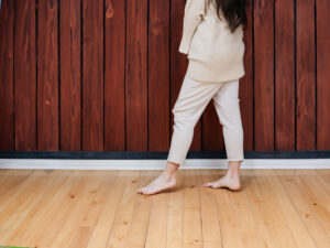 素足で歩く女性と無垢フローリング。明るい木目の床材が持つ自然な風合いと心地よさを表現したイメージ。