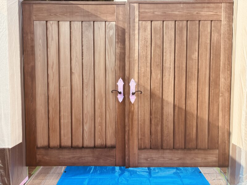 メンテナンス前のヒノキ無垢材の門扉。屋外使用による黒ずみや色ムラが見られる塗装前の状態