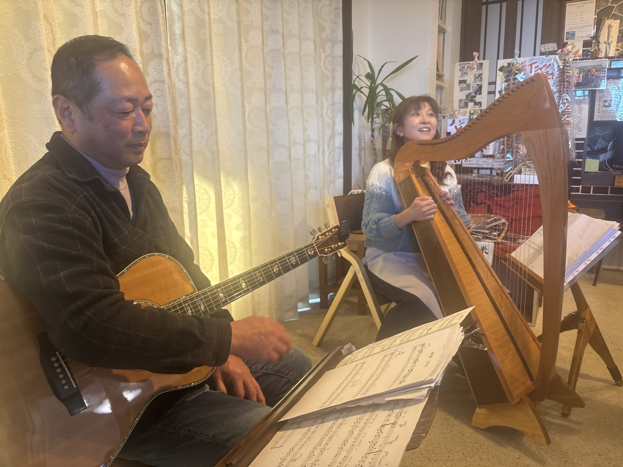 ギターと大和ハープによる演奏会の様子。木製のハープと演奏者が向かい合って音を奏でている