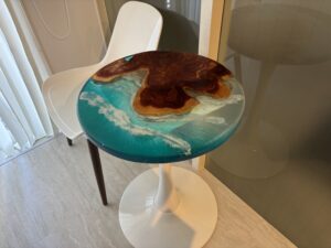 サロンの窓際に配置された海をデザインしたラウンドレジンテーブル