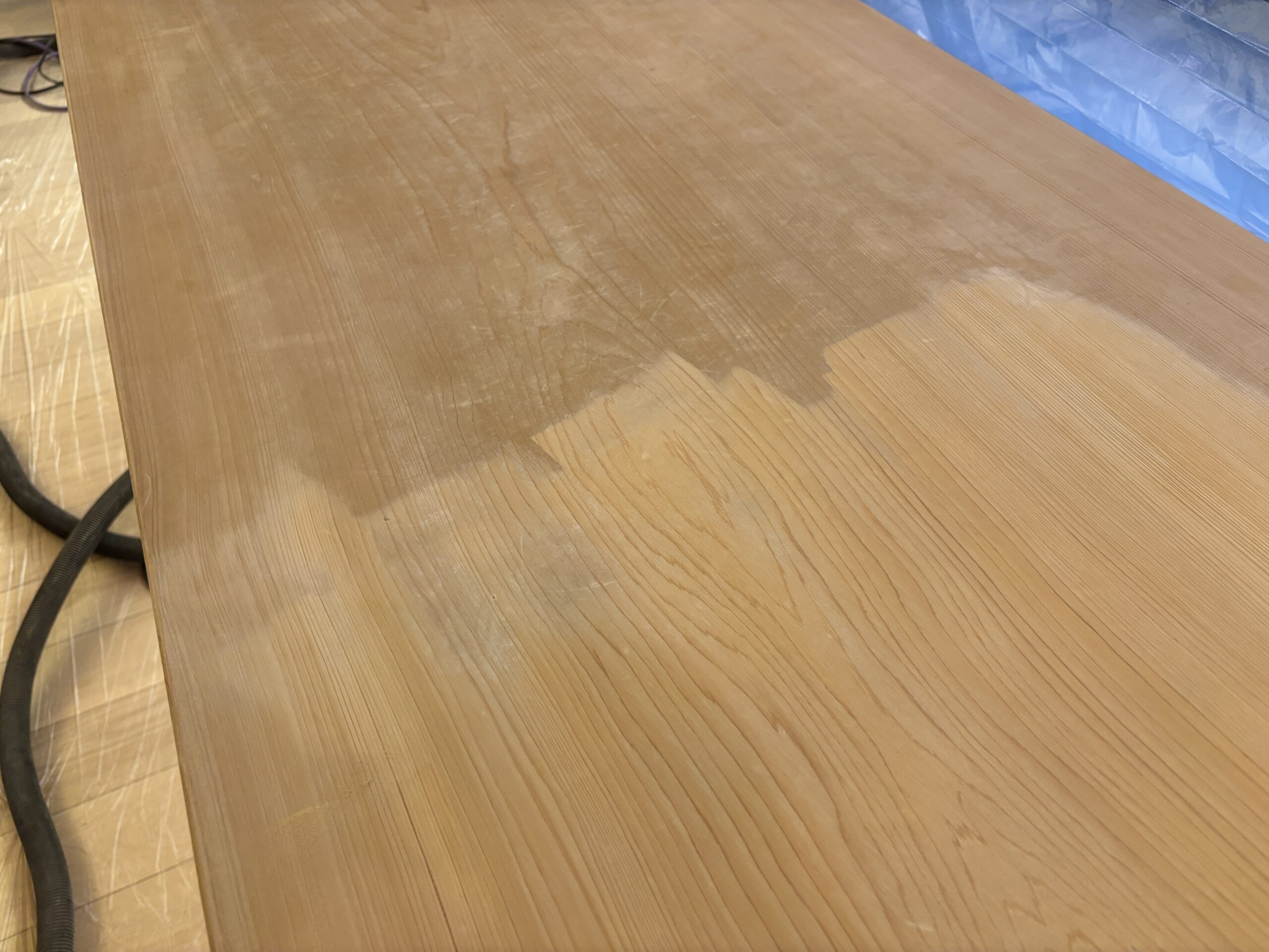 ヒノキカウンターの研磨途中。研磨前と研磨後の境目がはっきりと分かる状態