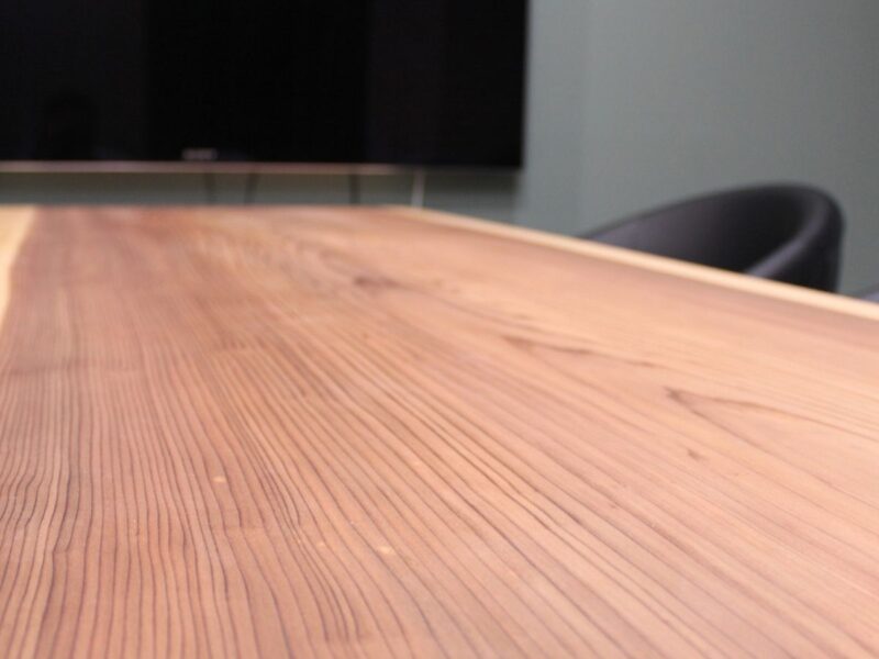 オフィス空間に設置された複数台の一枚板テーブル。木目や耳の表情がそれぞれ異なる無垢材天板。