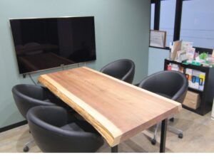 一枚板テーブルを斜めから撮影した写真。天板の厚みと耳付き部分の自然な形状が分かる。