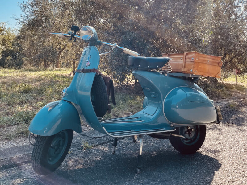 青緑色のベスパに木箱を載せたクラシックスタイルのスクーター