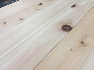 ヒノキ無垢フローリングの節部分に施された丸い埋木。節抜けを補修し、床材としての強度と見た目を整えている