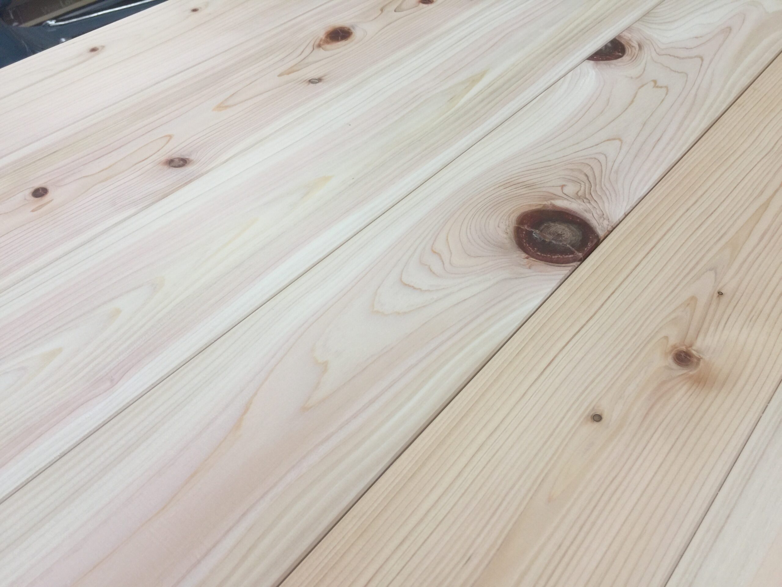 ヒノキ無垢フローリングの節部分に施された丸い埋木。節抜けを補修し、床材としての強度と見た目を整えている