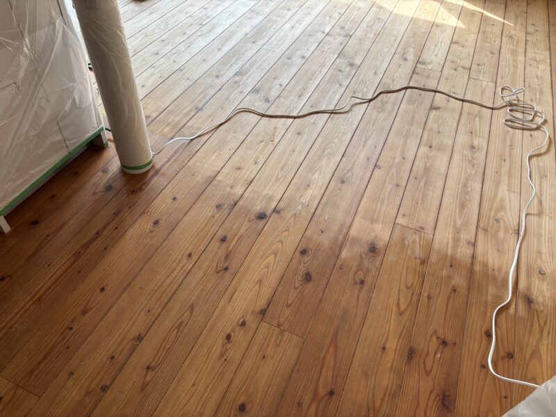 杉無垢フローリング研磨途中の全体写真。部屋全体で明るさの差が出ている