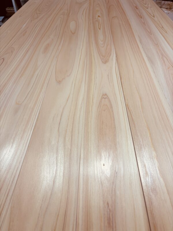 吉野ヒノキ無垢フローリングを斜めから撮影した写真。光が反射し、表面の滑らかさが分かる。