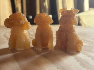 アンバー色のレジン製ワンちゃんフィギュア3体を無垢フローリングの上に並べて展示した写真