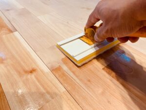 自然塗料「春風クリア」をシルバーチェリー無垢フローリングに塗装している様子