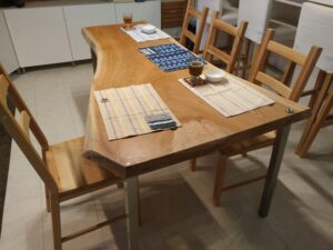 ケヤキの一枚板ダイニングテーブルを斜め上から撮影した納品事例。耳付き天板とアイアン脚の組み合わせ。