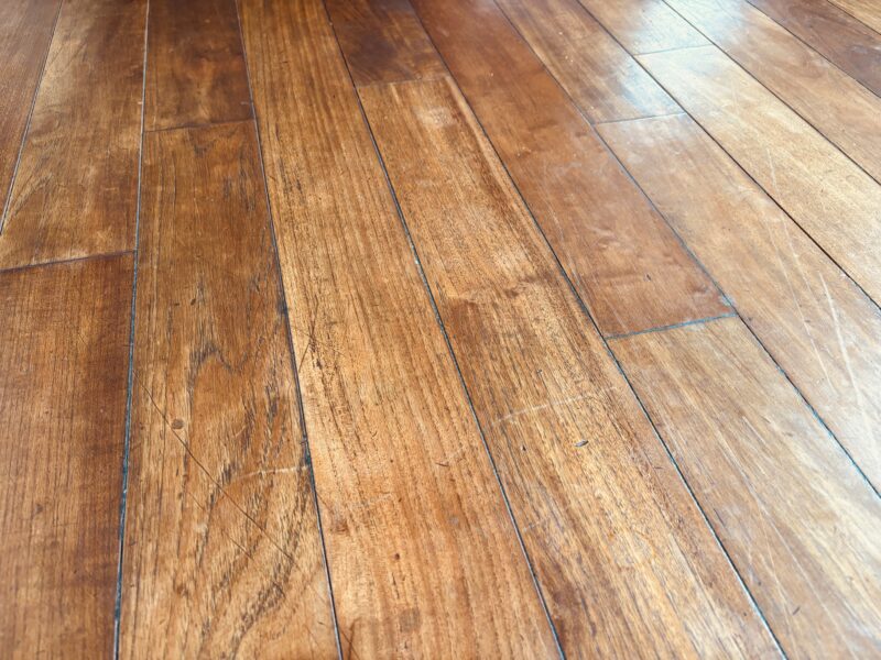 傷や擦れが目立つ施工後10年以上経過したインドネシアチーク無垢フローリングの表面
